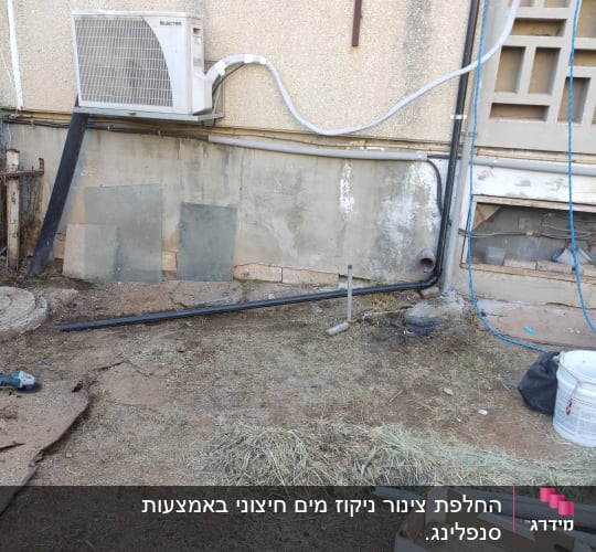 מזגן מותקן על קיר עם צינורות חשמל וציוד עבודה